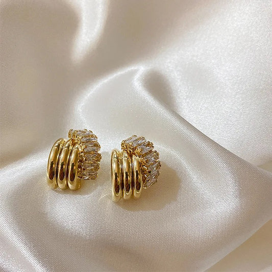 Gold vintage knot earrings with sparkling cubic zirconia stones. The earrings feature a unique knot design with multiple curved bands of gold.