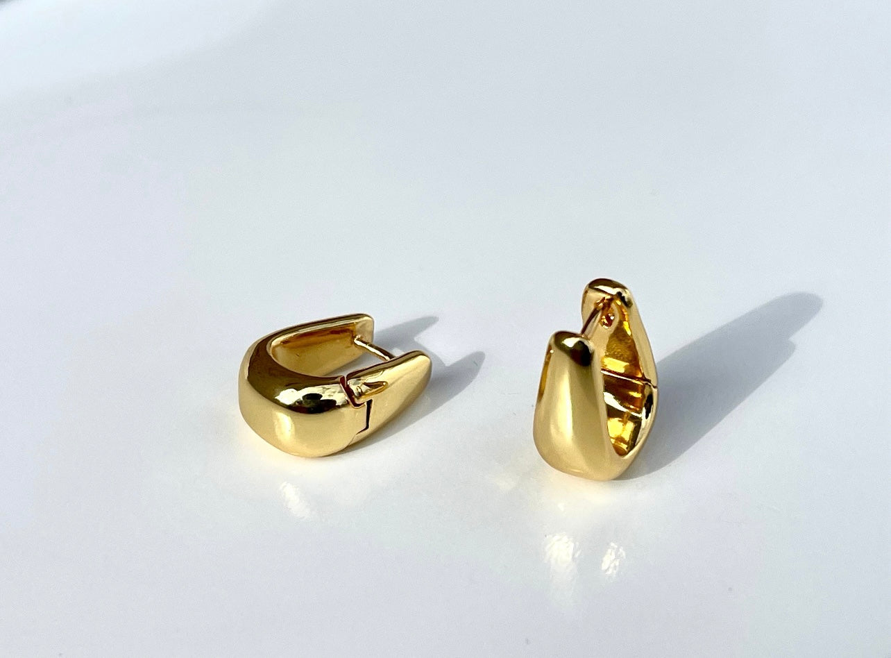 Hoop earrings with a teardrop-shaped dome and a gold-plated finishing.